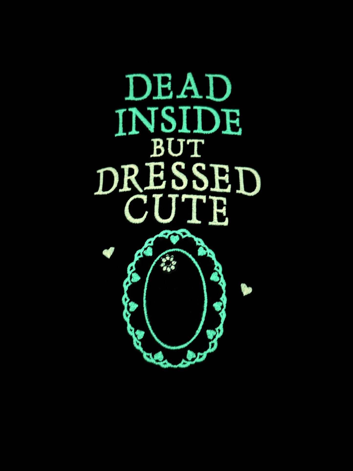 Glowing text 'Dead Inside But Dressed Cute' with a decorative border on a black background