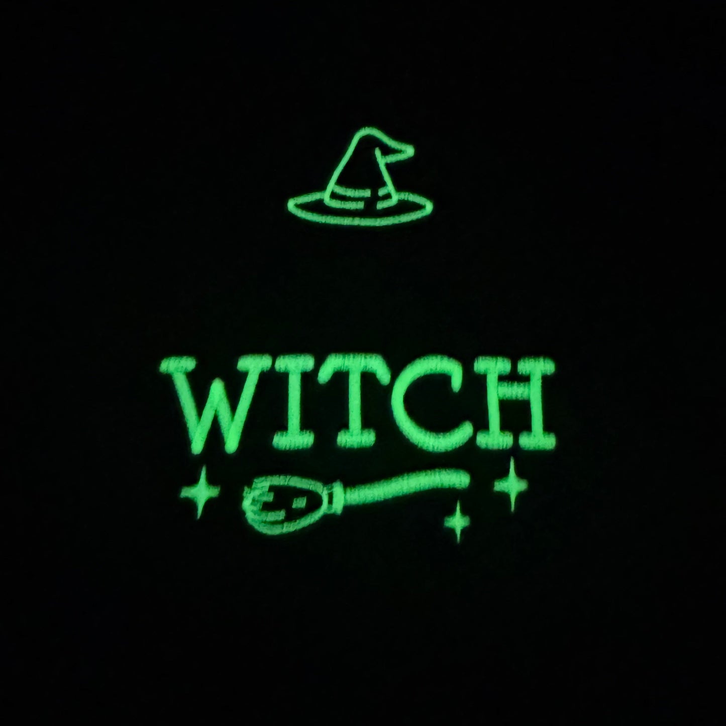 Glowing green text 'WITCH' with a broom and hat on a black background